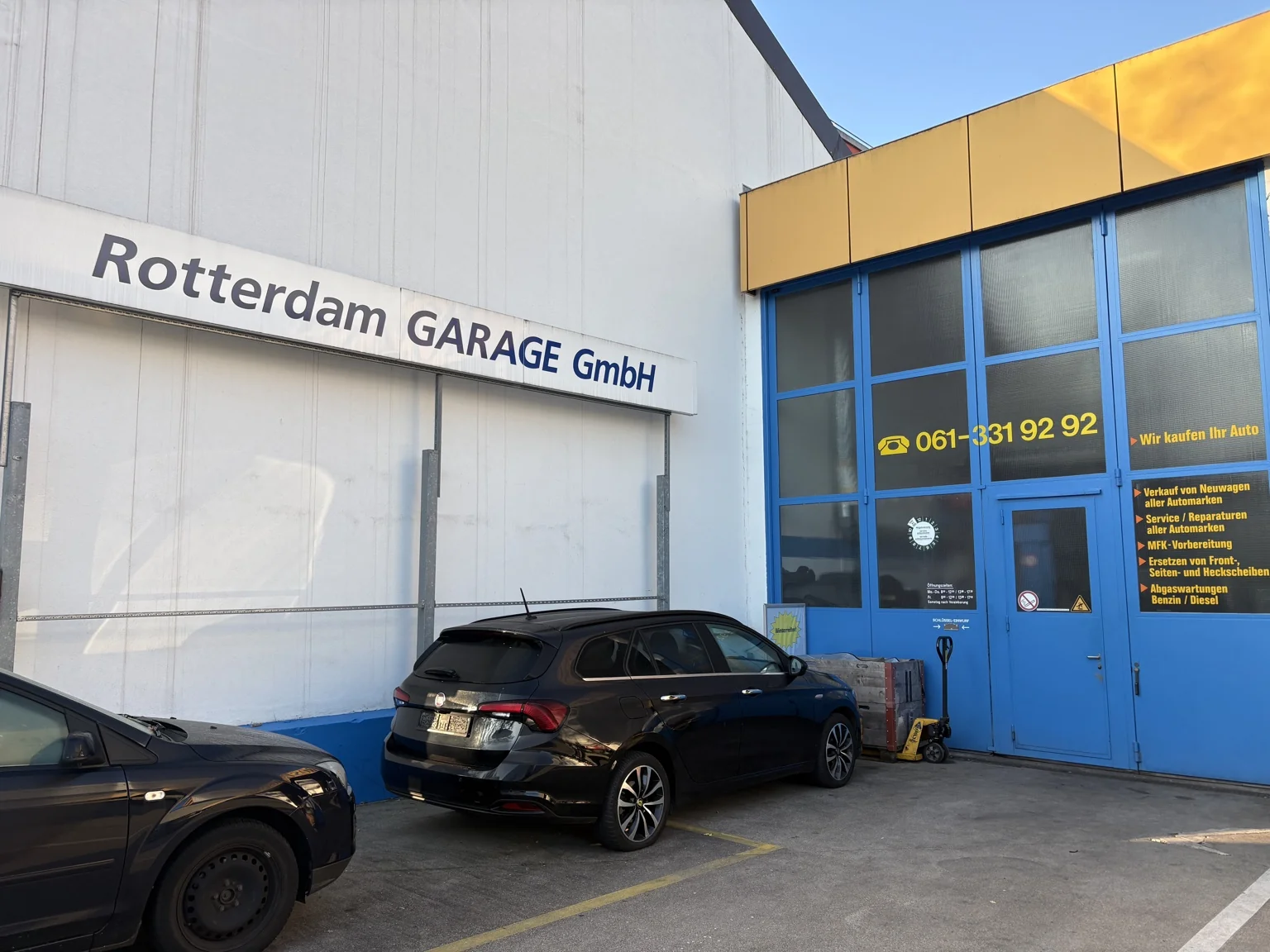 Haupteingang der Rotterdam Garage GmbH in Basel mit blauem Tor und Firmenschriftzug